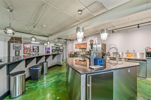 kitchen with a large island, pendant lighting, and stainless steel appliances