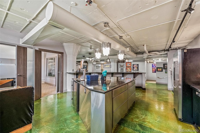 kitchen featuring decorative light fixtures, a large island, and stainless steel fridge with ice dispenser