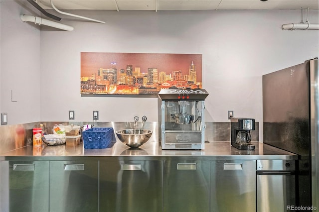 bar featuring stainless steel counters and black refrigerator