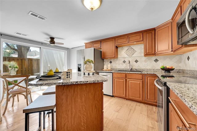 kitchen featuring ceiling fan, visible vents, appliances with stainless steel finishes, tasteful backsplash, and a sink
