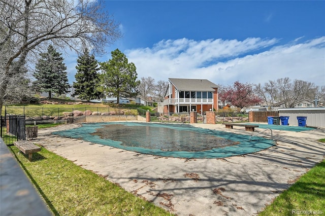 community pool with a patio and a fenced backyard