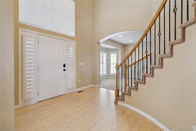 entryway with a high ceiling and light wood-type flooring