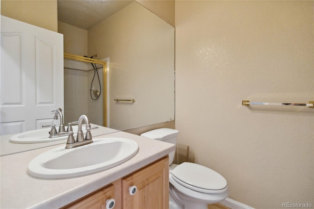 bathroom featuring walk in shower, toilet, and vanity