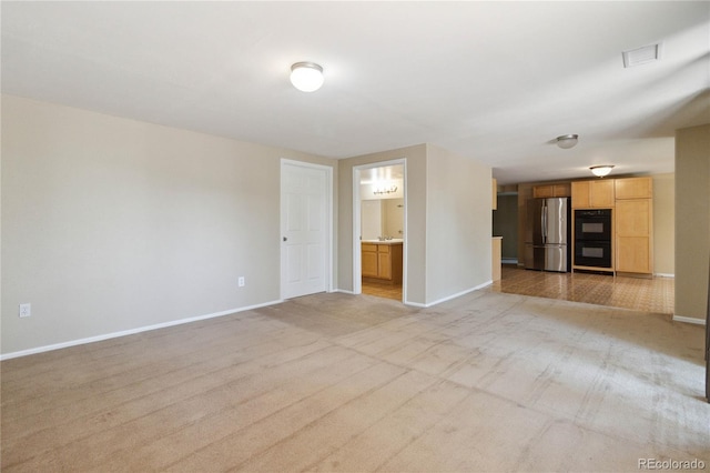 unfurnished living room featuring light colored carpet