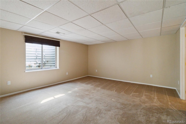 spare room with a paneled ceiling and carpet floors