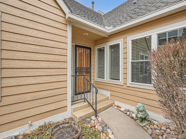 doorway to property with roof with shingles