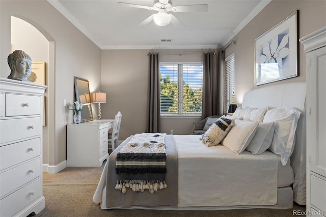 carpeted bedroom with ceiling fan and ornamental molding