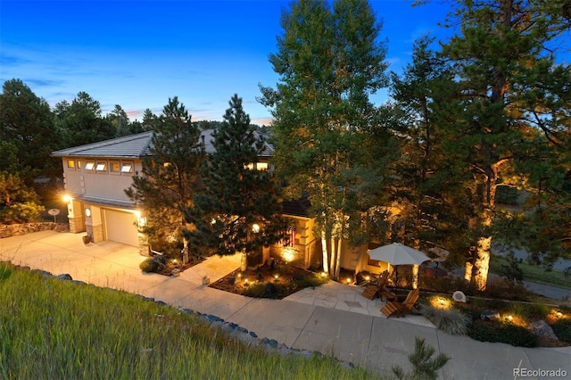 view of property hidden behind natural elements featuring a garage