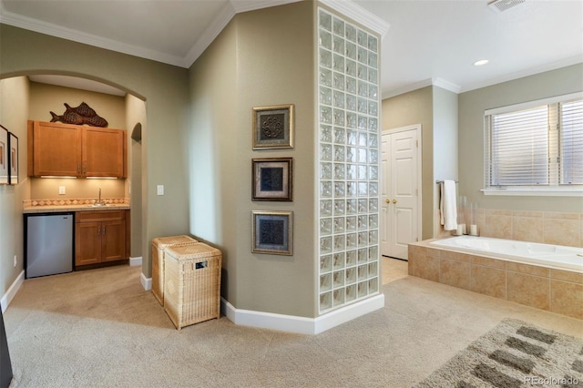 interior space with vanity, crown molding, and a relaxing tiled tub