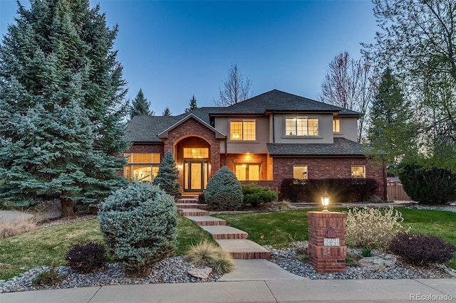 2464 Ginny Way, Lafayette, CO 80026 - view of front of house with roof with shingles, brick siding, stucco siding, and a front lawn