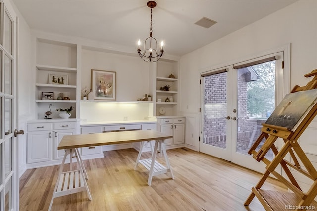 2464 Ginny Way, Lafayette, CO 80026 - office featuring french doors, built in shelves, light wood-style floors, and a chandelier