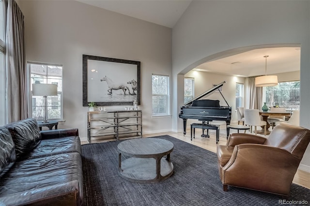 2464 Ginny Way, Lafayette, CO 80026 - living area featuring arched walkways, healthy amount of natural light, high vaulted ceiling, and baseboards