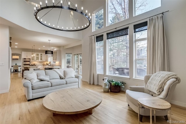2464 Ginny Way, Lafayette, CO 80026 - living room featuring light wood-style floors, a high ceiling, baseboards, recessed lighting, and a chandelier