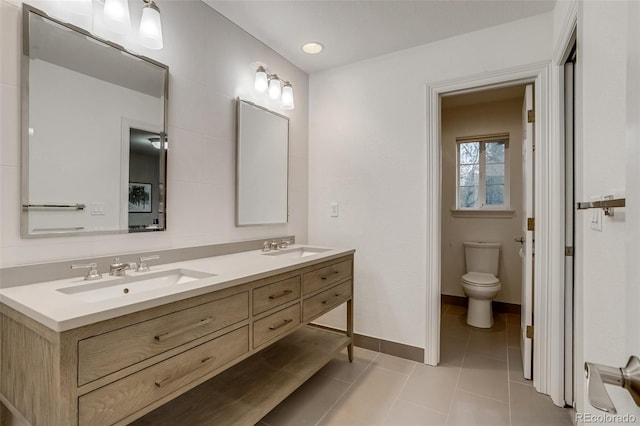 2464 Ginny Way, Lafayette, CO 80026 - full bath with double vanity, toilet, tile patterned floors, and baseboards