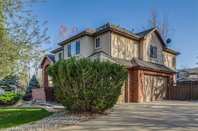 2464 Ginny Way, Lafayette, CO 80026 - view of front of house with stucco siding, a garage, driveway, and brick siding