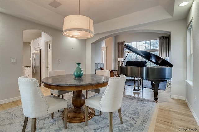 2464 Ginny Way, Lafayette, CO 80026 - dining area with arched walkways, light wood-style flooring, and baseboards