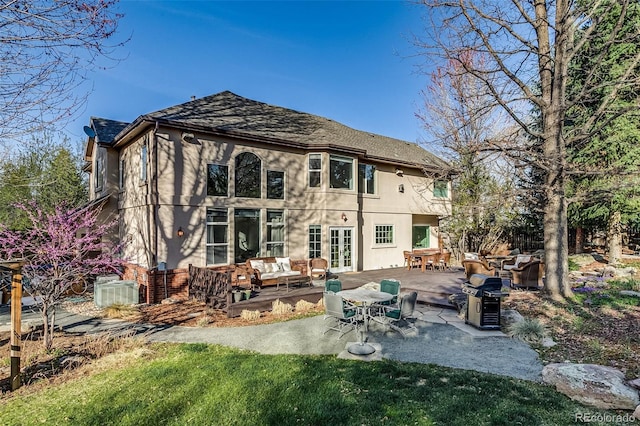 2464 Ginny Way, Lafayette, CO 80026 - back of house featuring french doors, an outdoor hangout area, a patio area, a lawn, and stucco siding