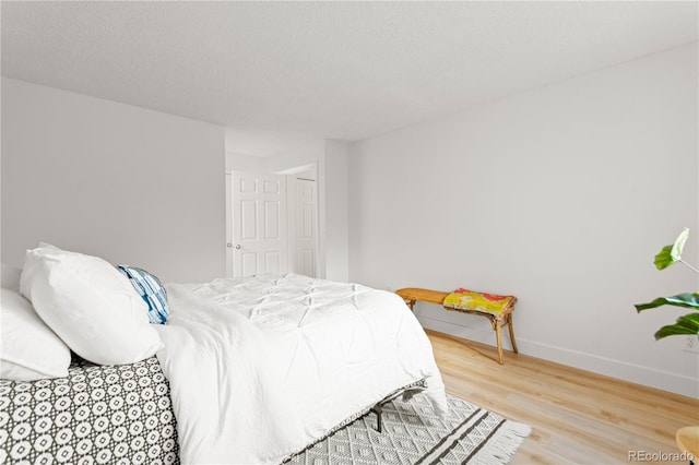 bedroom with hardwood / wood-style flooring and a textured ceiling