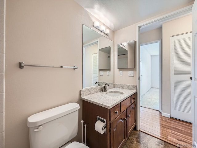 bathroom featuring hardwood / wood-style flooring, vanity, and toilet