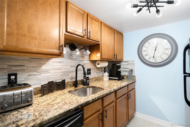 7780 W 38th Ave Unit 203, Wheat Ridge, CO 80033 - kitchen featuring a sink, tasteful backsplash, light stone counters, black dishwasher, and baseboards