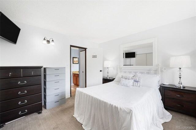 7780 W 38th Ave Unit 203, Wheat Ridge, CO 80033 - bedroom featuring light colored carpet and ensuite bath
