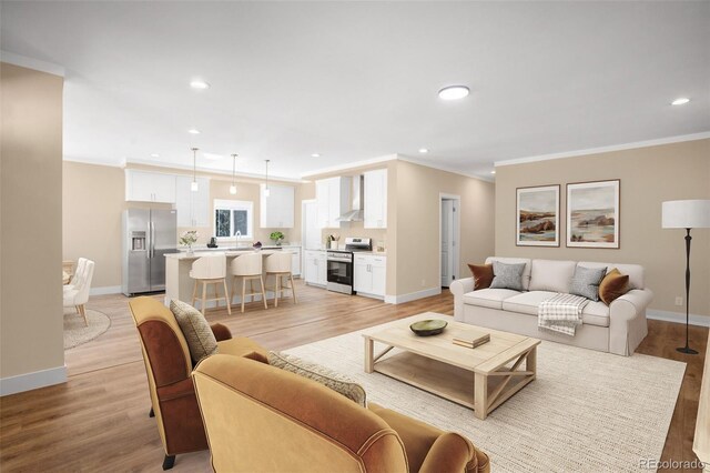 living room featuring ornamental molding, sink, and light hardwood / wood-style flooring