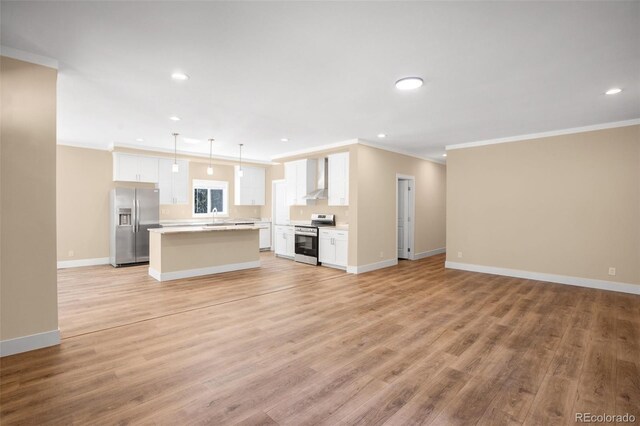 unfurnished living room with light wood-type flooring, ornamental molding, and sink