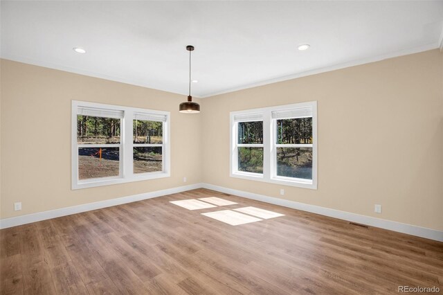 unfurnished dining area with hardwood / wood-style floors and crown molding