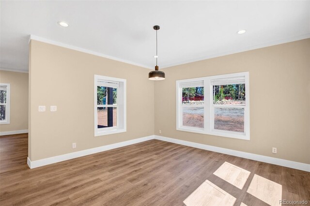 empty room with wood-type flooring and ornamental molding