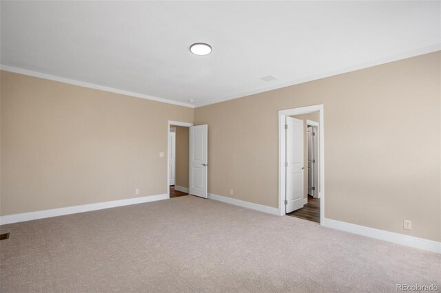 unfurnished room featuring crown molding and carpet flooring