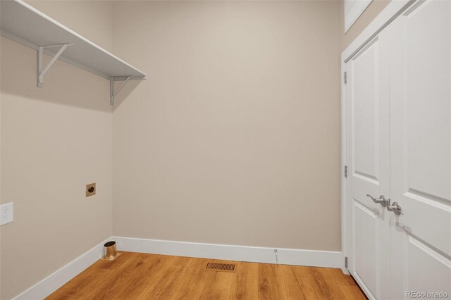 laundry area featuring light wood-type flooring and hookup for an electric dryer