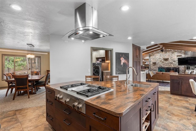 kitchen with pendant lighting, sink, island range hood, a center island with sink, and washer / clothes dryer