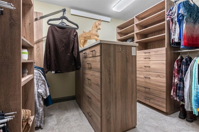 walk in closet featuring light carpet