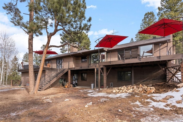 rear view of property featuring a wooden deck