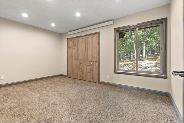 unfurnished bedroom featuring a textured ceiling and carpet