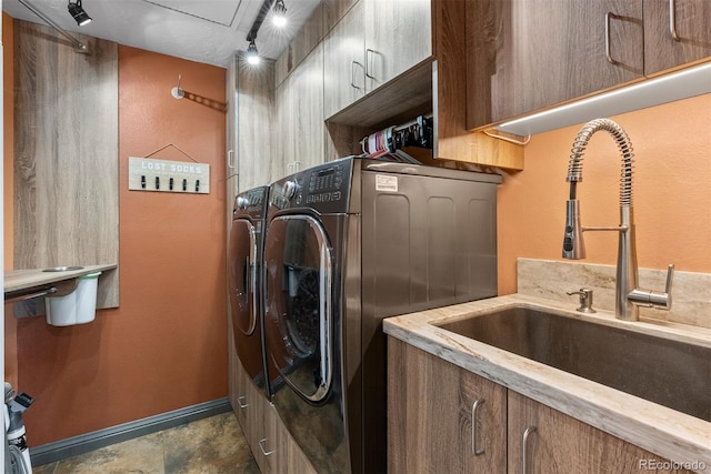 washroom featuring cabinets, sink, and washing machine and clothes dryer