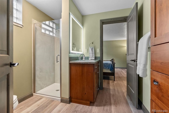 bathroom featuring vanity, toilet, an enclosed shower, and hardwood / wood-style floors