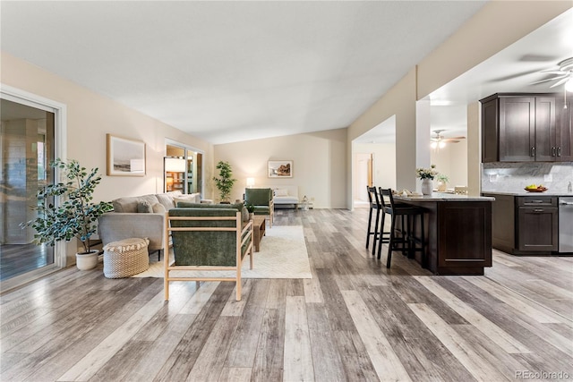 living room featuring lofted ceiling and light hardwood / wood-style flooring