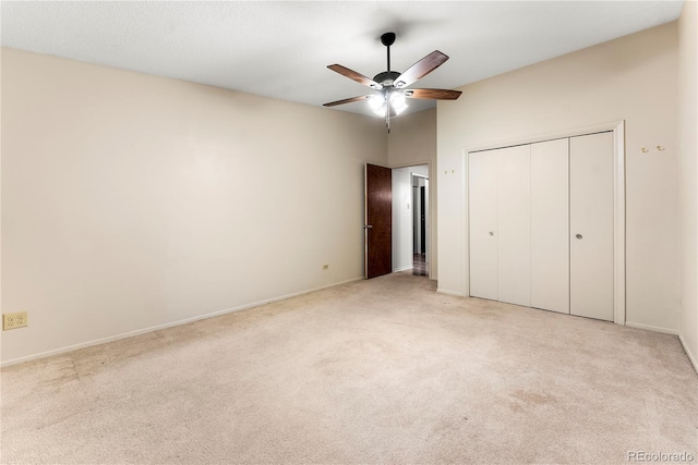 unfurnished bedroom with ceiling fan, a closet, and light carpet