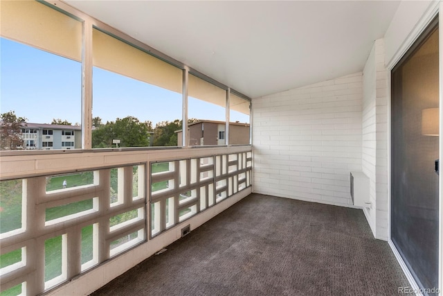 unfurnished sunroom featuring vaulted ceiling