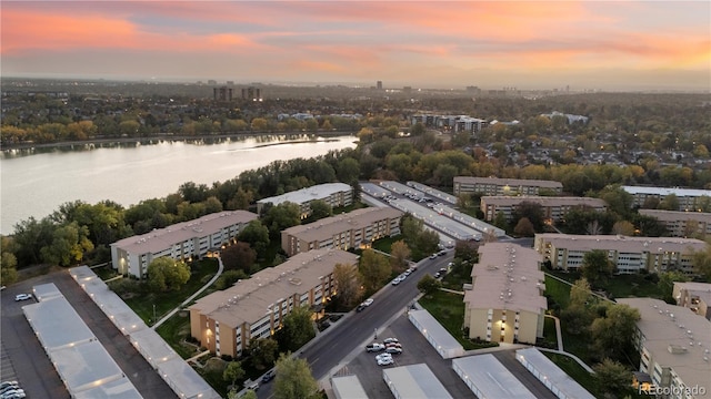 aerial view at dusk featuring a water view