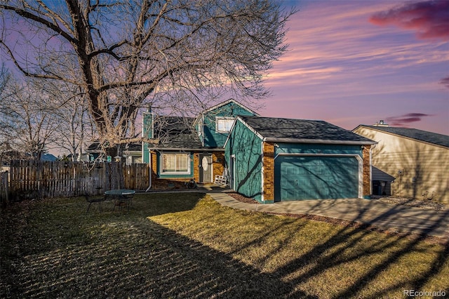 view of front of home with an attached garage, brick siding, fence, driveway, and a front lawn