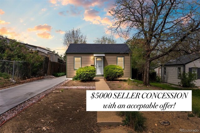 bungalow-style house with fence