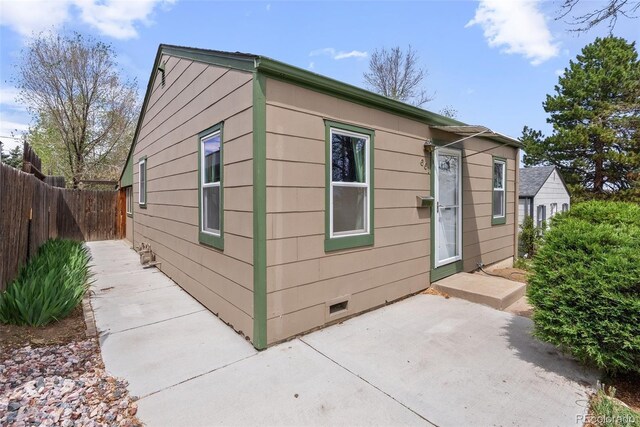 view of home's exterior with a patio and fence