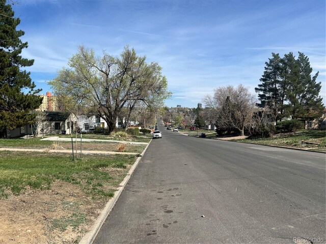 view of asphalt road featuring curbs and sidewalks