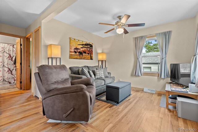 living area with ceiling fan, light wood-style floors, and baseboards