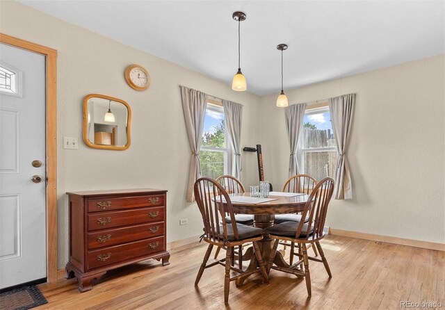 dining space with light wood-style floors and baseboards