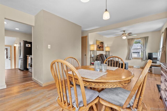 dining room with light wood-type flooring, ceiling fan, and baseboards