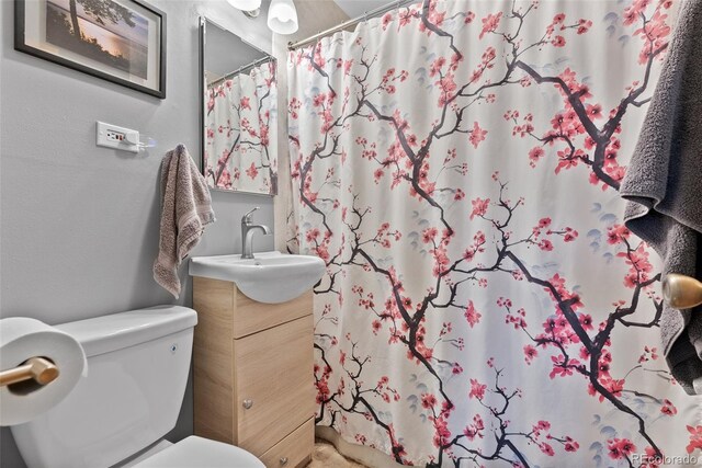 full bathroom featuring toilet, vanity, a shower with curtain, and a textured wall