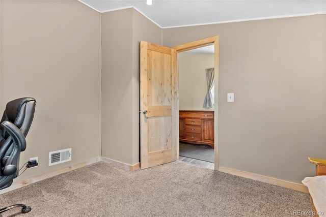 unfurnished office featuring crown molding, carpet floors, and baseboards